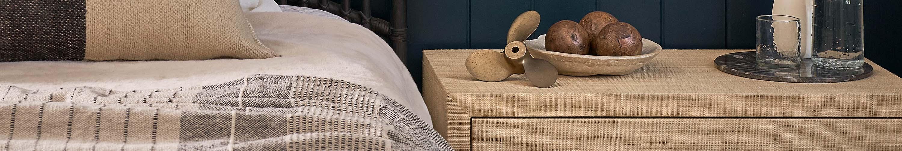 Wood nightstand by brown bed